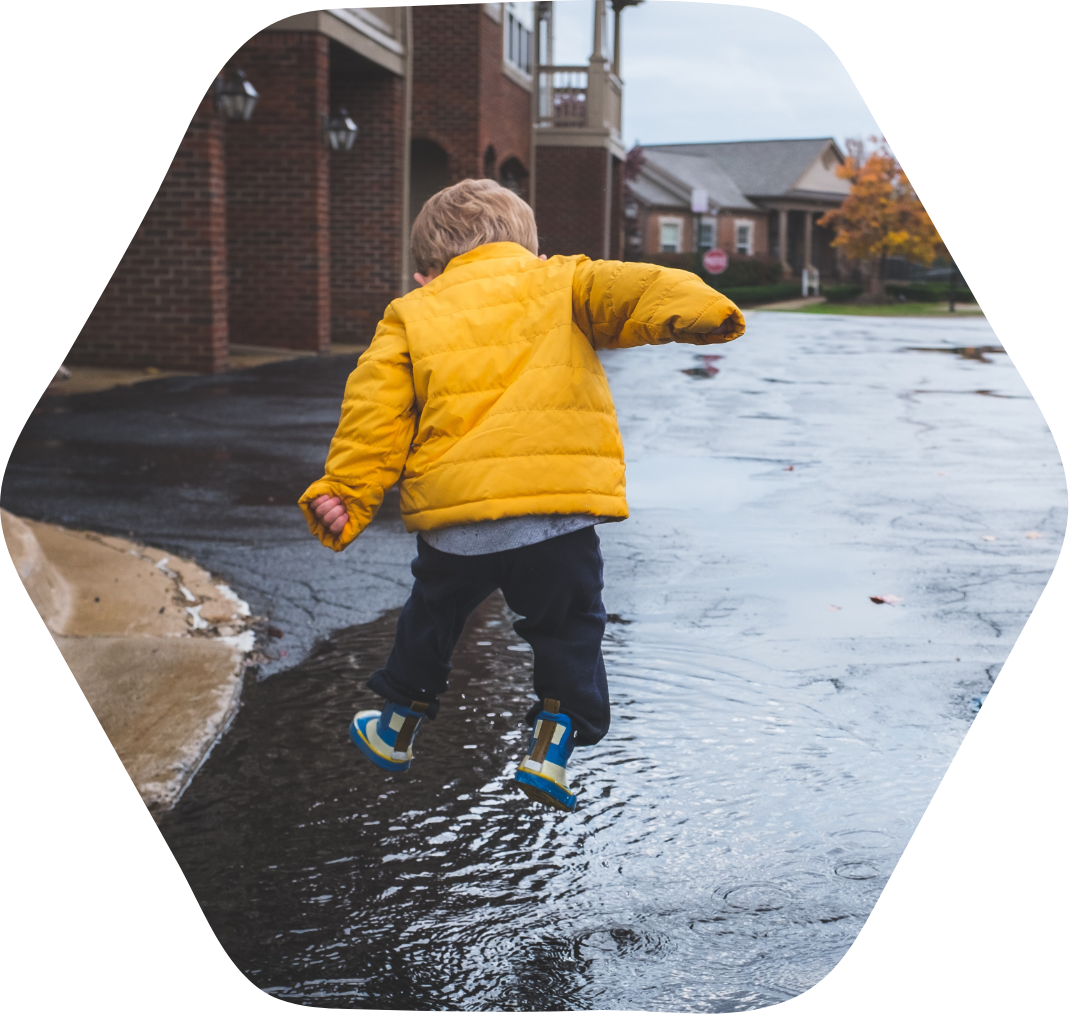 A kid jumping in a puddle