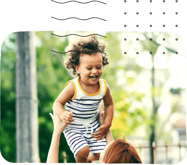 A Woman holding a laughing child in the air
