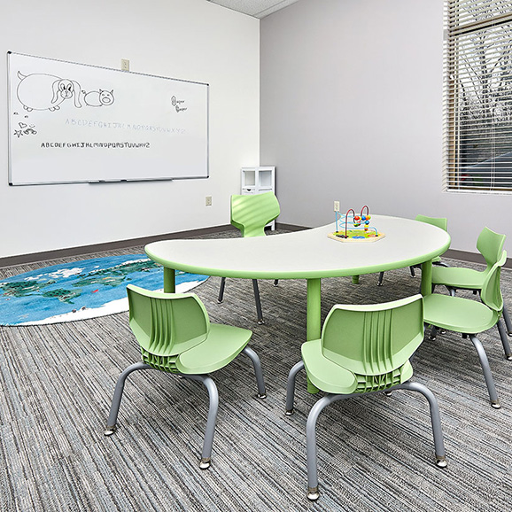 Classroom with whiteboard, table and chairs where children with autism learn skills during their full-day ABA program near Des Moines, Iowa.