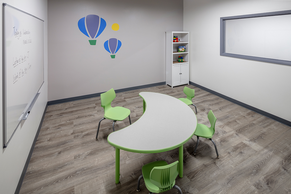 Classroom with whiteboard, table and chairs where children with autism learn skills during their full-day ABA program near Albany Park, Illinois.