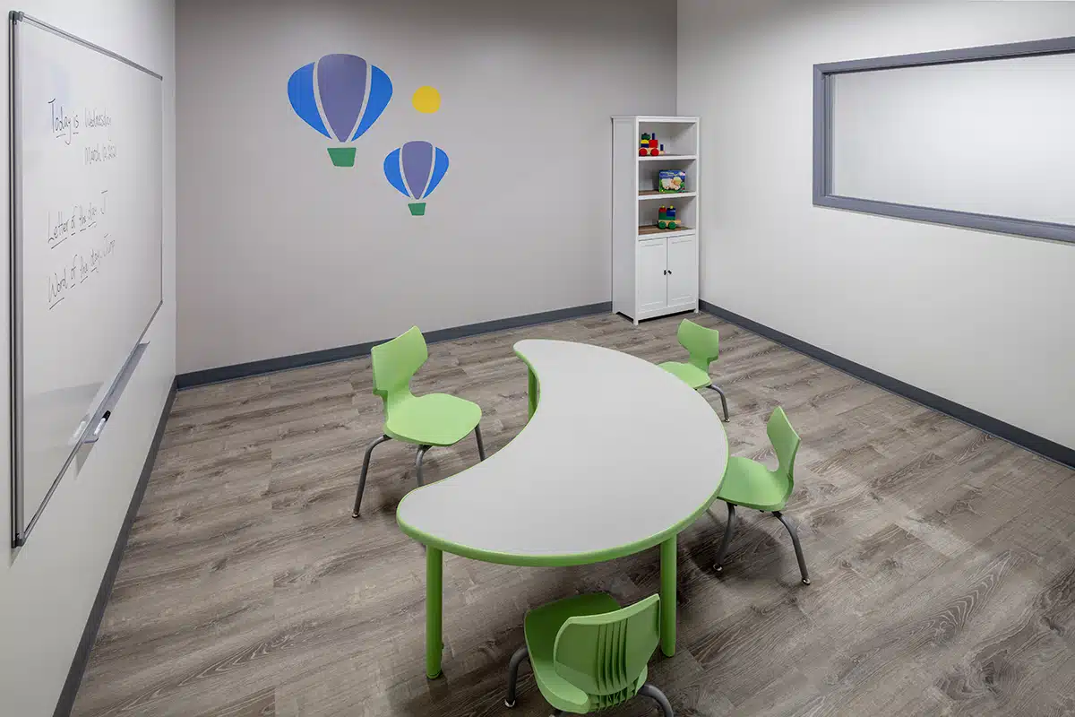 Classroom with whiteboard, table and chairs where children with autism learn skills during their full-day ABA program near Forest Glen in Chicago, Illinois.