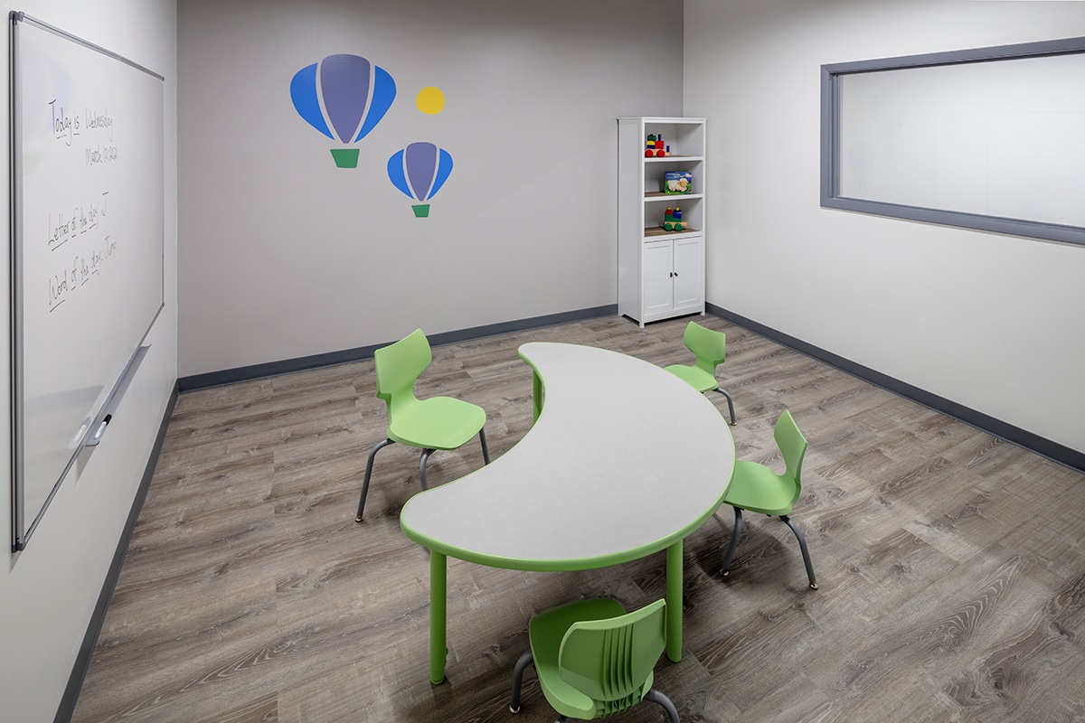 Classroom with whiteboard, table and chairs where children with autism learn skills during their full-day ABA program near Fuller Park in Chicago, Illinois.