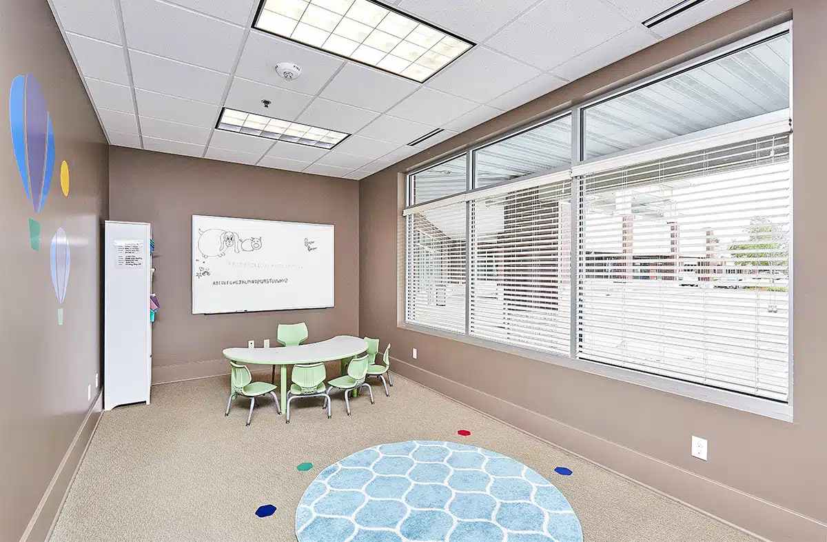 Classroom with whiteboard, table and chairs where children with autism learn skills during their full-day ABA program near Sheldahl, Iowa.