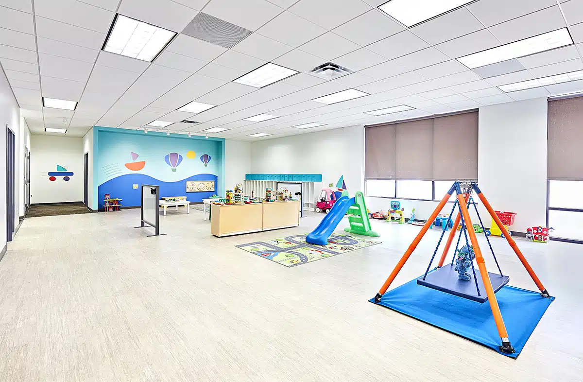 View of interior open space with toys, a table, and multiple doors at the Stride Autism Center near Clinton, Iowa.