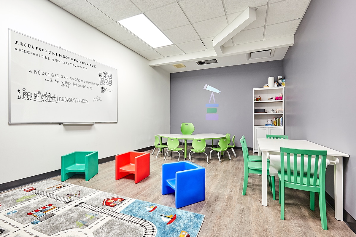 Classroom with whiteboard, table and chairs where children with autism learn skills during their full-day ABA program near Alvo, Nebraska.