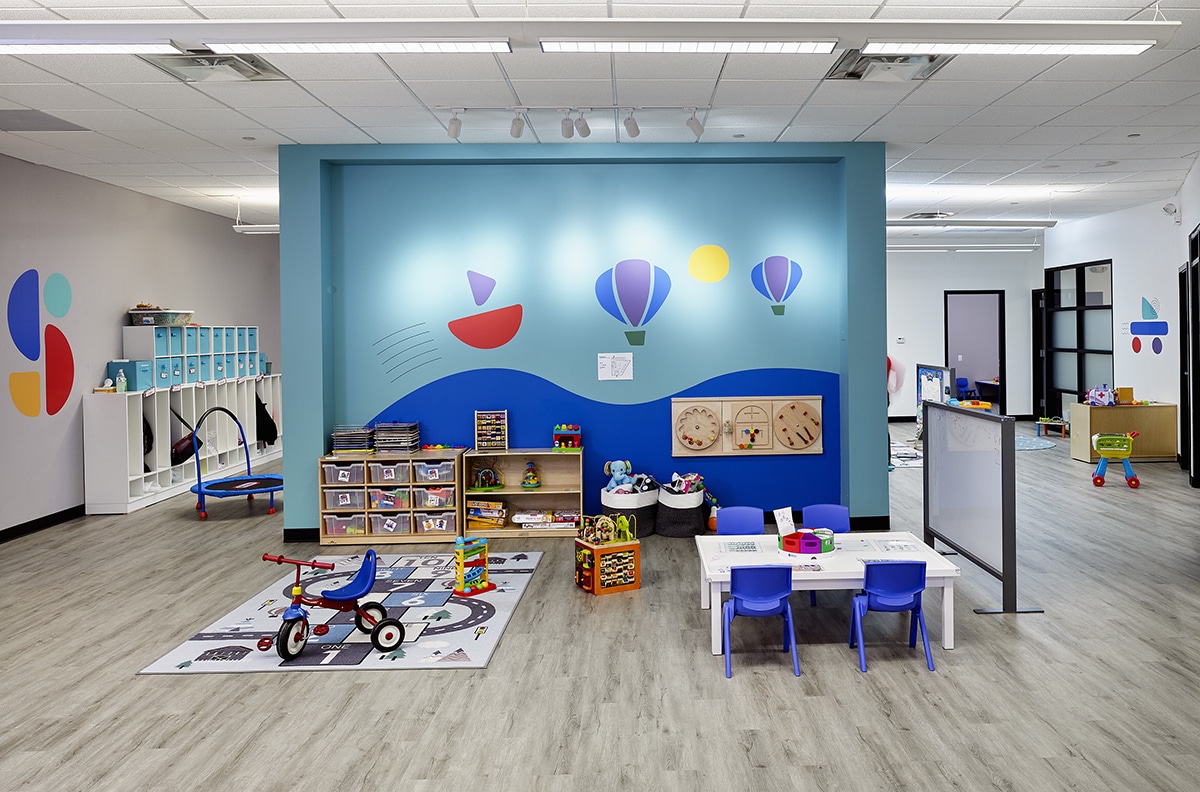 View of interior open space with toys, a table, chairs, and cubby area at the Stride Autism Center near 82nd Ave, Hickory Hills, IL.
