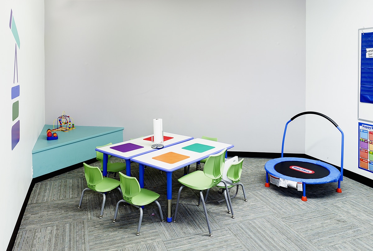 Classroom with table, chairs and small trampoline where children with autism learn skills during their full-day ABA program near Berwyn, IL.