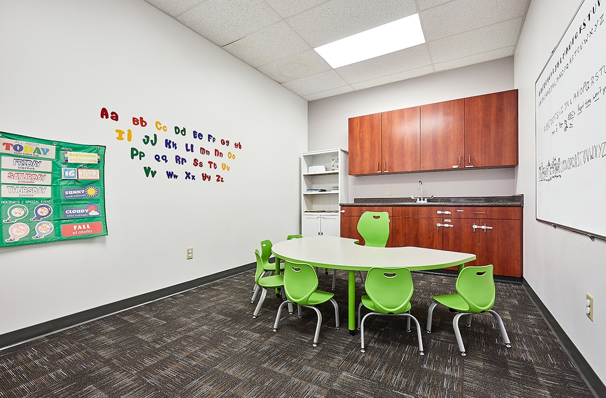 Classroom with whiteboard, table and chairs where children with autism learn skills during their full-day ABA program near Council Bluffs, Nebraska.