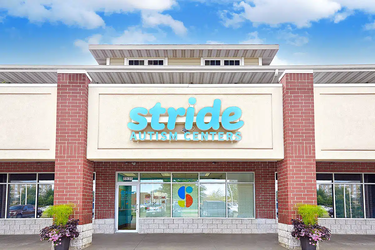 Photo of a building with a signage that reads "Stride Autism Centers." The building is surrounded by trees and greeneries.