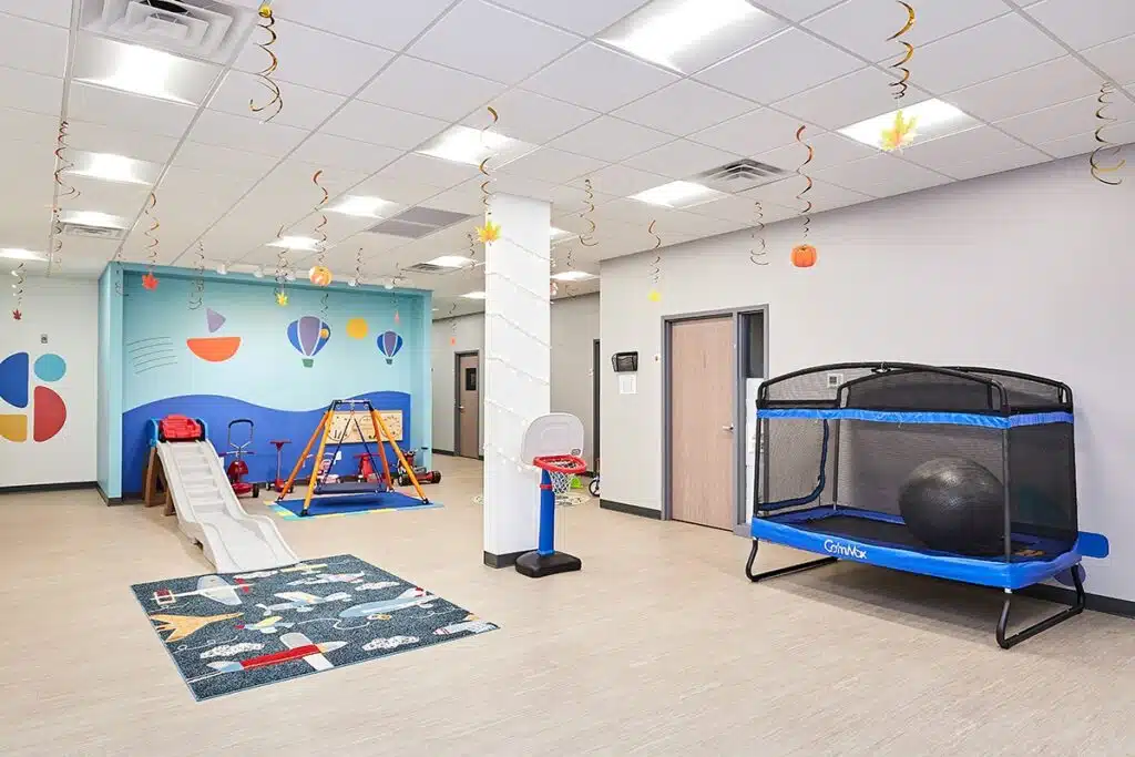 Una sala de terapia colorida y luminosa en Stride Autism Centers® en West Omaha, Nebraska, equipada con mobiliario adaptado a los niños.