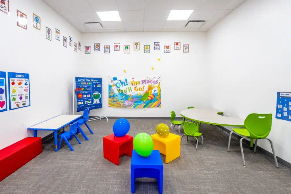 A colorful and bright therapy room at Stride Autism Centers&reg; in Oak Park, IL, featuring kid-sized tables and some toys.