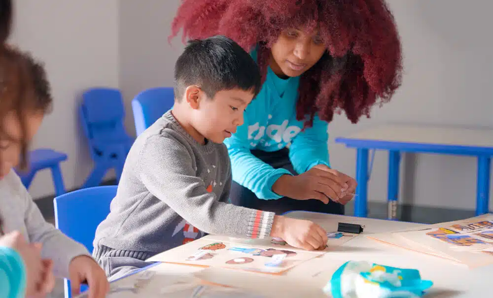 A young student focuses on a learning activity using picture cards during an ABA therapy session at Stride.