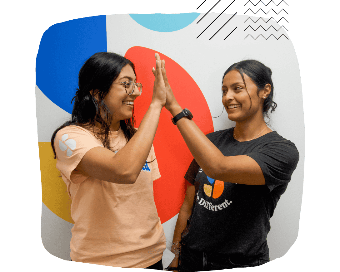 Stride Centers therapists high-five, representing collaboration in ABA therapy.