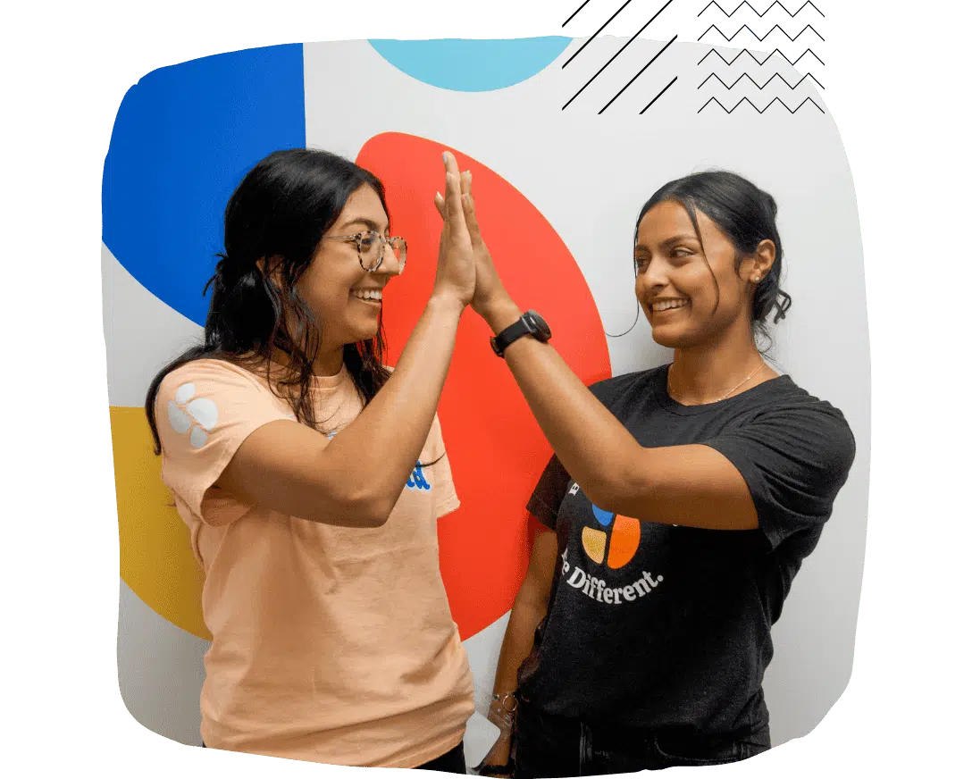 Stride Centers therapists high-five, representing collaboration in ABA therapy.