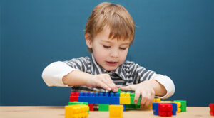 Una imagen de miniatura a todo color para una entrada de blog sobre el uso de los bloques LEGO como herramienta terapéutica para niños con autismo.