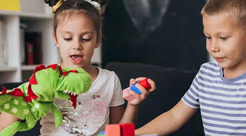 Un grupo de niños jugando juntos con bloques, lo que ilustra el desarrollo social y las habilidades sociales en Stride Autism Centers®.