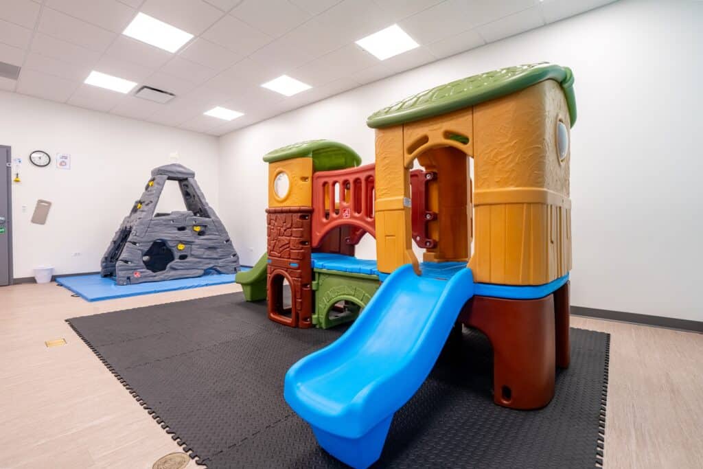 A colorful and bright therapy room at Stride Autism Centers&reg; in Waukee, IA, featuring child-sized tables and toys.